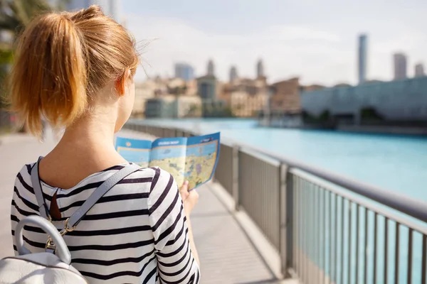 Chica turista viaja con mapa por las calles de la ciudad — Foto de Stock