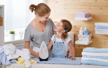 Mutlu aile anne ev hanımı ve çocuk kız elbise Ütü