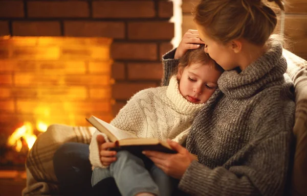 Feliz familia madre e hija leer libro en invierno eveni — Foto de Stock