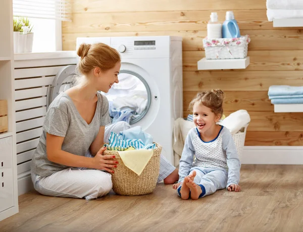 Happy family mother housewife and child   in laundry with washin — Stock Photo, Image