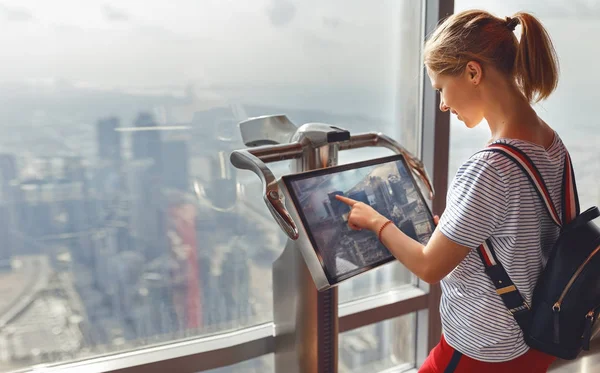 Chica turista con monitor de ordenador en ventana de rascacielos —  Fotos de Stock