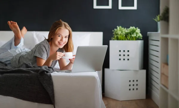 Молодая красивая женщина с ноутбуком и чашкой кофе в Morni — стоковое фото