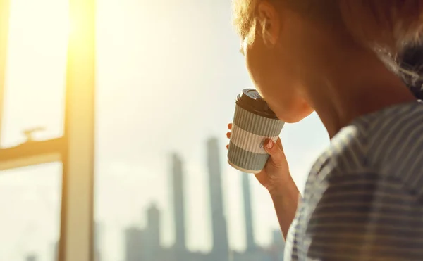 Happy young woman drinks coffee in morning at window — Stock Photo, Image