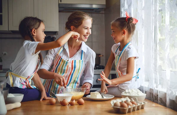 Lyckliga familjen mor och barn tvillingar baka knåda degen i — Stockfoto