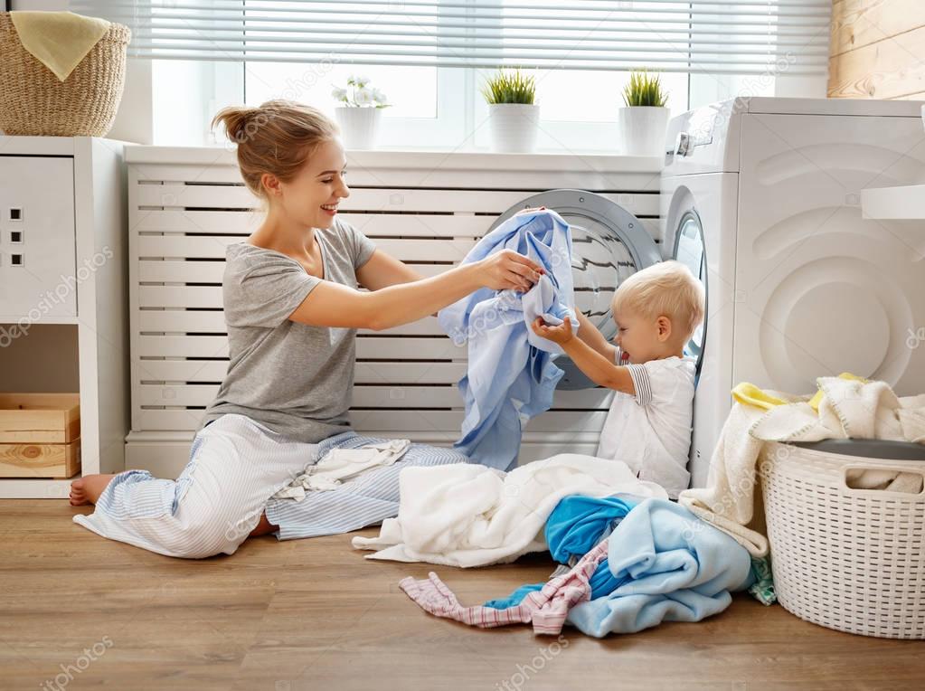 Happy family mother   housewife and   baby son in   laundry load