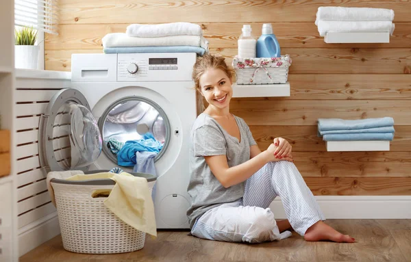 Mujer ama de casa feliz en la sala de lavandería con lavadora — Foto de Stock