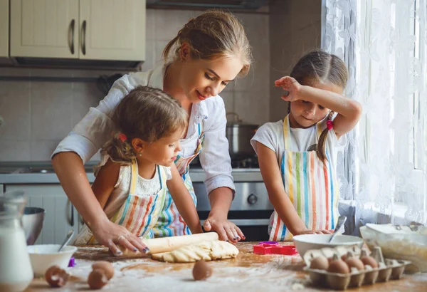 Feliz família mãe e filhos gêmeos assar amassar massa em — Fotografia de Stock