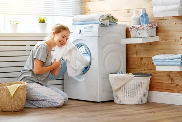 Šťastná žena v domácnosti v prádelně s pračkou — Stock fotografie