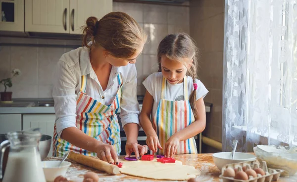 Lyckliga familjen mor och dotter baka knåda degen i köket — Stockfoto
