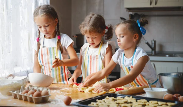 Siostry szczęśliwy dzieci dziewczyny piec ciasteczka, Zagnieść ciasto, grać dowcip — Zdjęcie stockowe