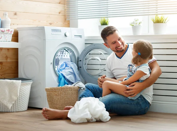 Щасливий сімейний чоловік батько домогосподарка і дитина в пральні з — стокове фото