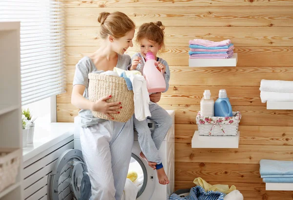 Lycklig familj mamma hemmafru och barn i tvättstuga med tvättmaskin — Stockfoto