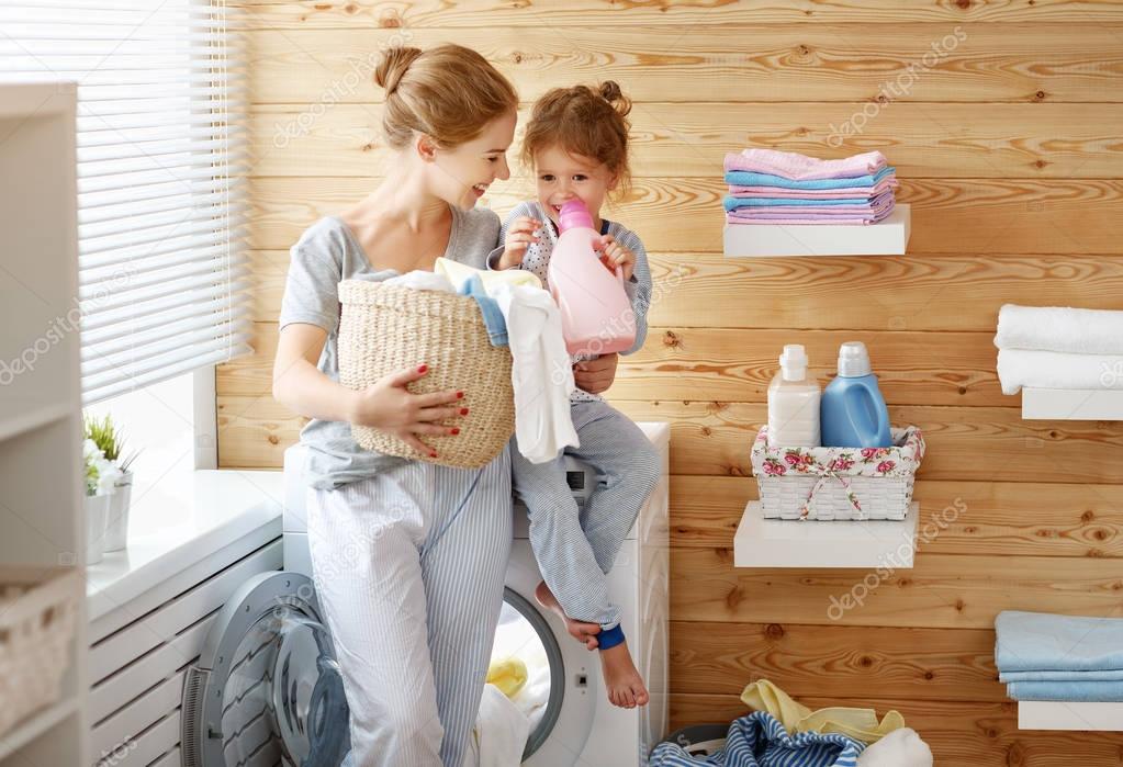 Happy family mother housewife and child   in laundry with washin