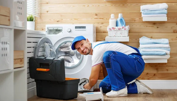Trabalho homem encanador reparos máquina de lavar roupa na lavanderia — Fotografia de Stock