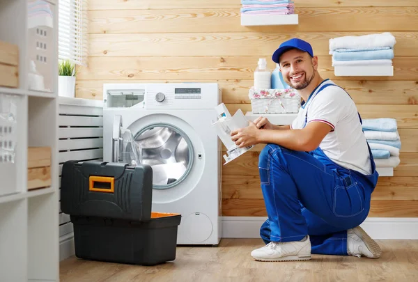 Hombre trabajador fontanero reparaciones lavadora en lavandería — Foto de Stock