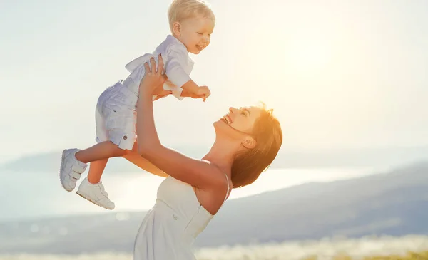 Gelukkige familie moeder en zoontje lachen in de natuur — Stockfoto