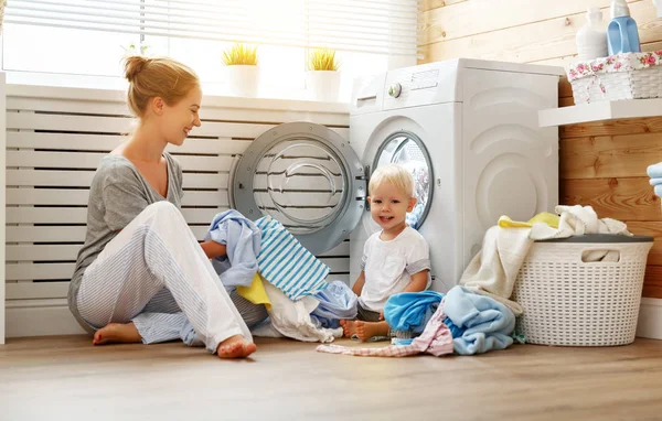 Glückliche Familienmutter Hausfrau und kleiner Sohn in der Wäscheladung — Stockfoto