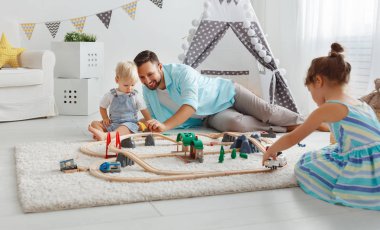 aile baba ve çocuk oyun odası bir oyuncak tren oyna