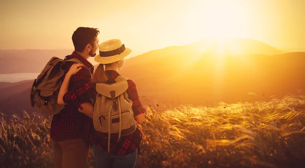 Ευτυχισμένο ζευγάρι άνδρας και γυναίκα τουρίστα στην κορυφή του βουνού στο ηλιοβασίλεμα — Φωτογραφία Αρχείου