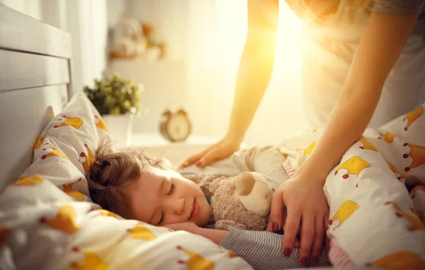 Mãe acorda dormindo criança filha menina em mornin — Fotografia de Stock