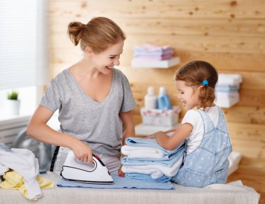 Mutlu aile anne ev hanımı ve çocuk kız elbise Ütü