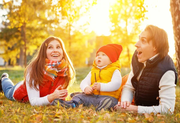 Feliz familia madre padre y bebé en otoño paseo en el parque — Foto de Stock