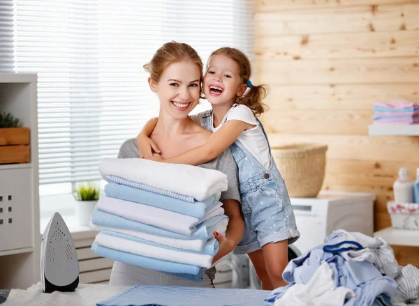 Happy family mother housewife and child daughter ironing clothes — Stock Photo, Image
