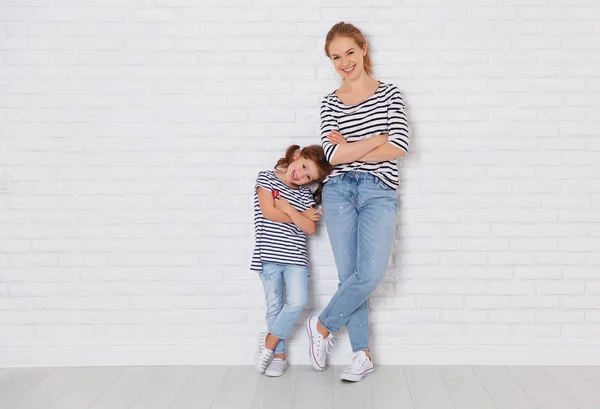 Happy family mother and child daughter near an empty wall — Stock Photo, Image