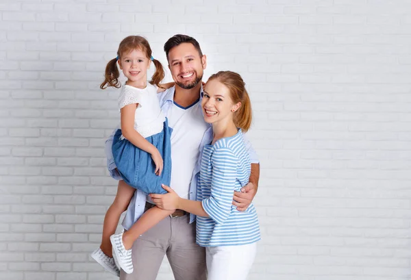 Felice famiglia madre padre e figlio vicino a un muro di mattoni vuoto — Foto Stock