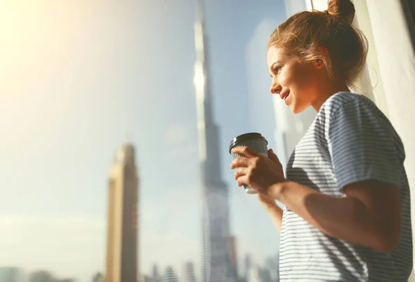 Gelukkig jonge vrouw drinkt koffie in de ochtend bij raam — Stockfoto