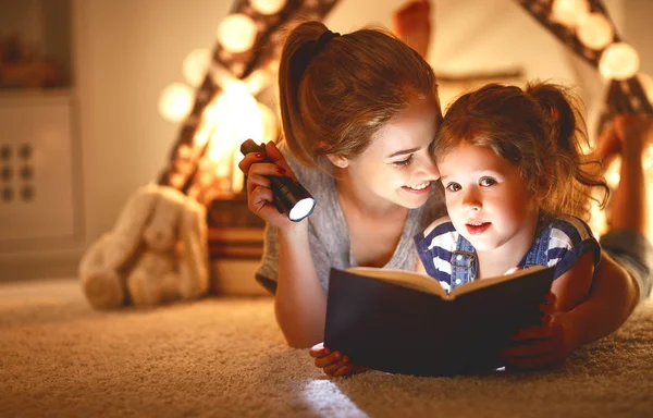 Mother and child daughter with a book and a flashlight before go — Stock Photo, Image