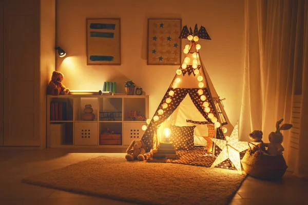 Interior da sala de jogos infantil com tenda, lâmpadas e brinquedos em dar — Fotografia de Stock