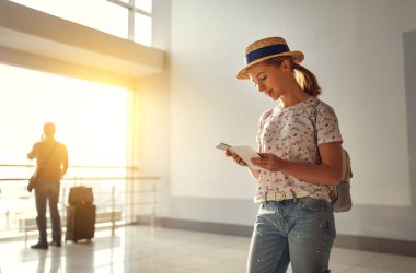 suitcas ile pencerede havaalanında uçtuğunuz için bekleyen genç kadın
