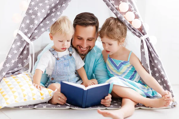 Familjen far läsning för barnbok i tältet på hom — Stockfoto
