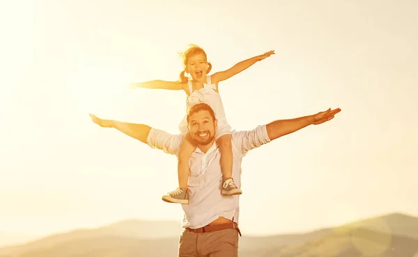 Father's day. child daughter sits on her dad shoulders outdoors — Stock Photo, Image