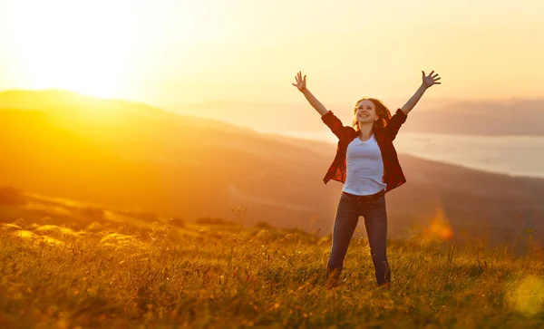 Mujer feliz al atardecer en la naturaleza con las manos abiertas —  Fotos de Stock