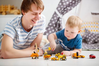 mutlu aile baba ve oğul oyuncak araba oyun odası oynamak