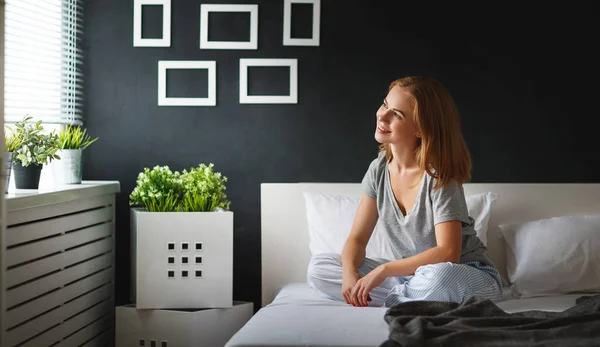 Ung kvinna som vaknade på morgonen i sovrummet av windo — Stockfoto