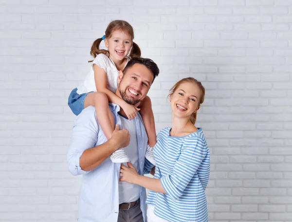 Lyckliga familjen mamma, Pappa och barn nära en tom tegelvägg — Stockfoto