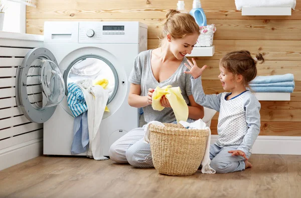 Hospodyňka šťastné rodiny matka a dítě v prádelně s washin — Stock fotografie