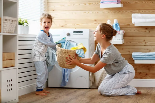 Νοικοκυρά ευτυχισμένη οικογένεια μητέρα και παιδί σε πλυντήριο με ενδύματ — Φωτογραφία Αρχείου