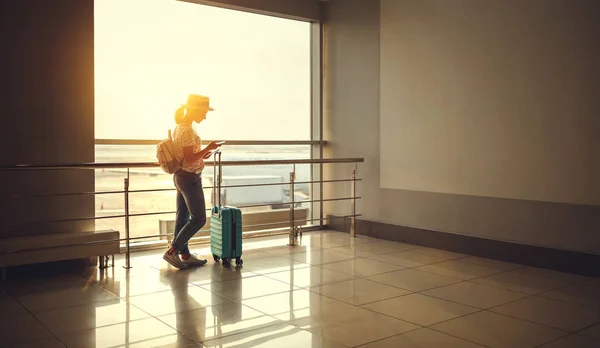 Jeune femme attendant de voler à l'aéroport à la fenêtre avec des valises — Photo