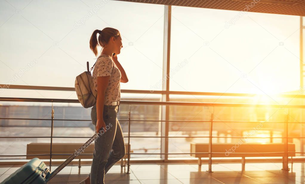 woman talking on phone waiting for flying at airport  at window 