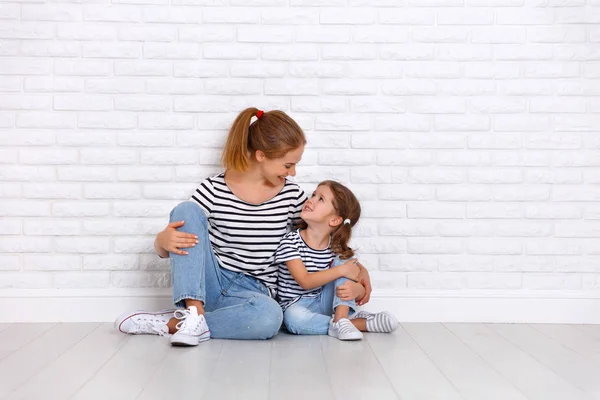 Happy family mother and child daughter near an empty wall — Stock Photo, Image