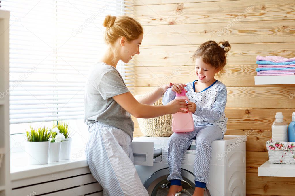 Happy family mother housewife and child   in laundry with washin