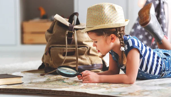 funny child girl tourist with world map, backpack and magnifie