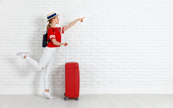 Concetto di viaggio e turismo. ragazza con valigia rossa vicino em bianco — Foto Stock