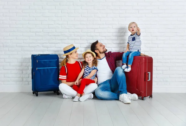 Концептуальные путешествия и туризм. счастливая семья с чемоданами рядом с W — стоковое фото