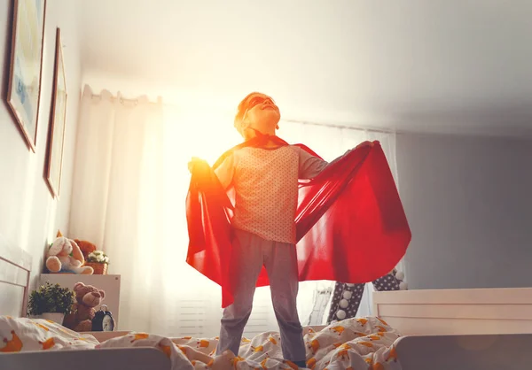 Kindermädchen im Superheldenkostüm mit Maske und rotem Mantel — Stockfoto