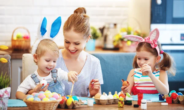 Happy easter! family mother and children paint eggs for   holida